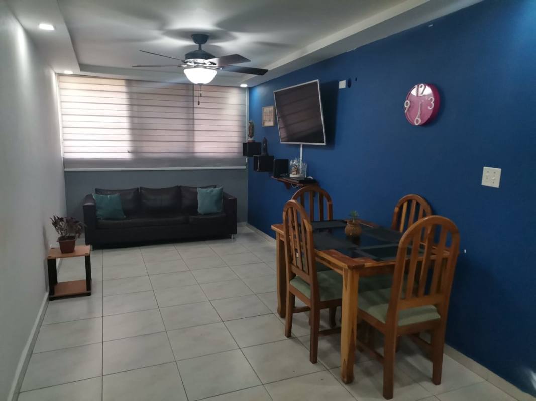 Living and dining space with blue accent wall, furniture and TV in Llano Bonito Panama