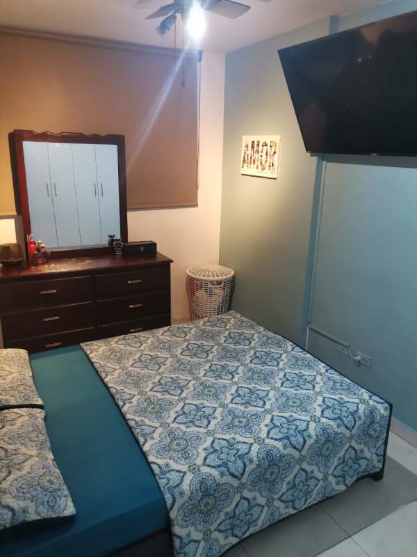 Cozy bedroom with ceiling fan mounted TV closet in Llano Bonito apartment