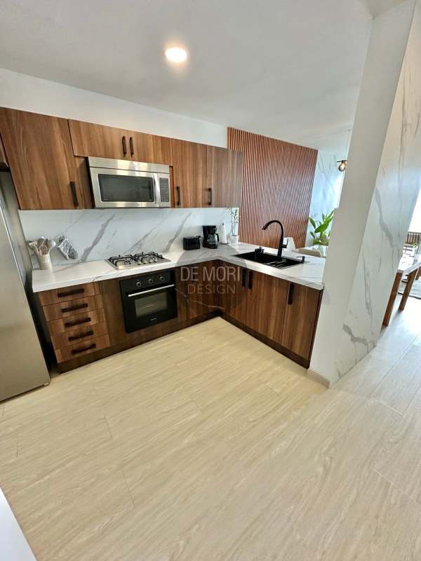 Modern kitchen with marble-look counters wood cabinetry and stainless appliances at Punta Pacifica tower