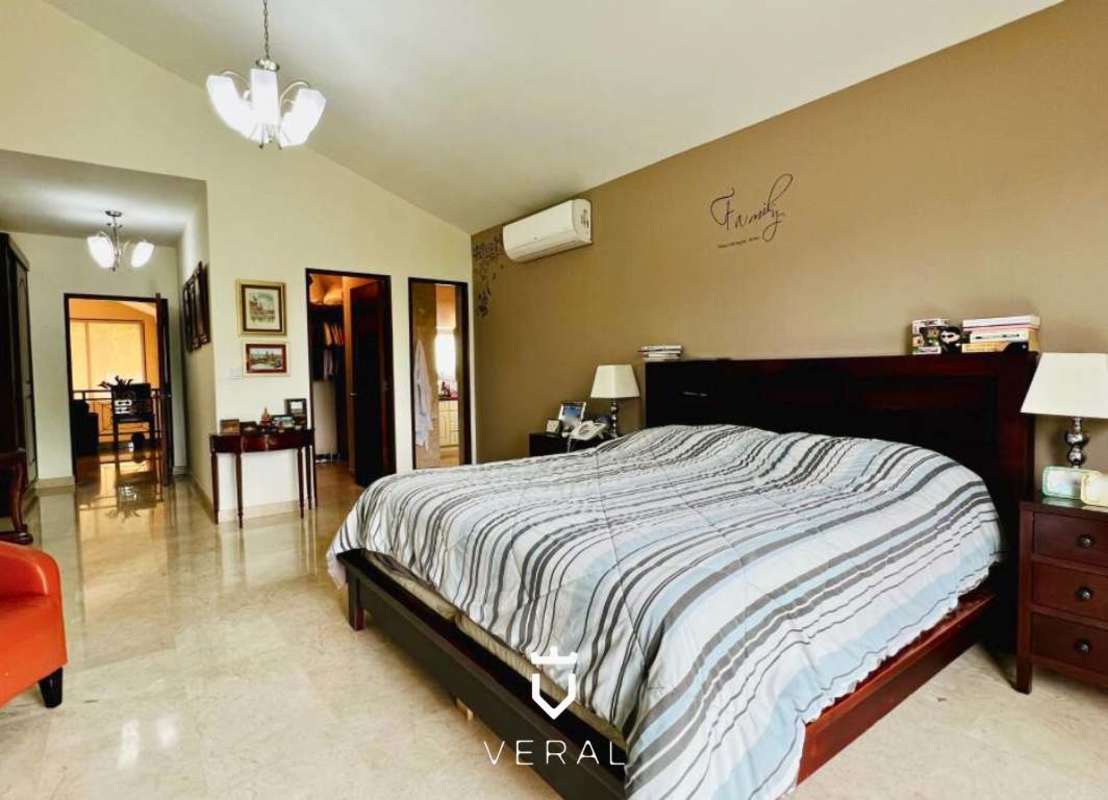 Master bedroom with vaulted ceiling and large window overlooking garden in Clayton estate