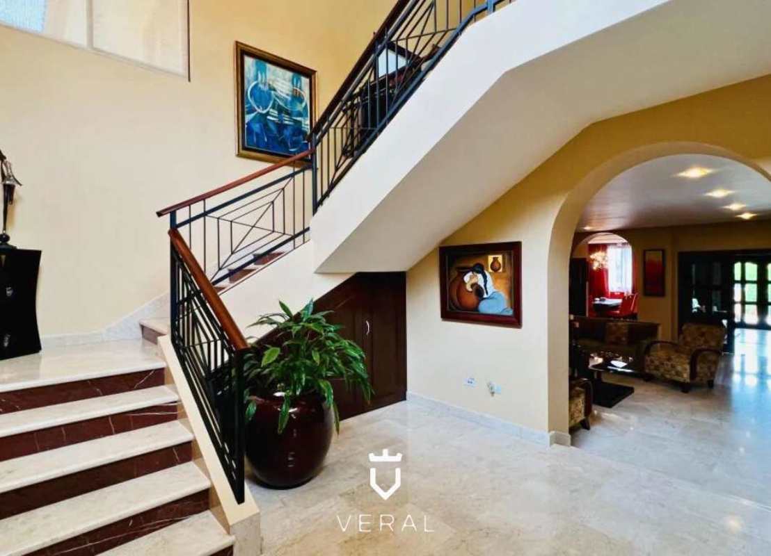 Spacious living room with marble floors and sectional sofa in Camino de Cruces residence