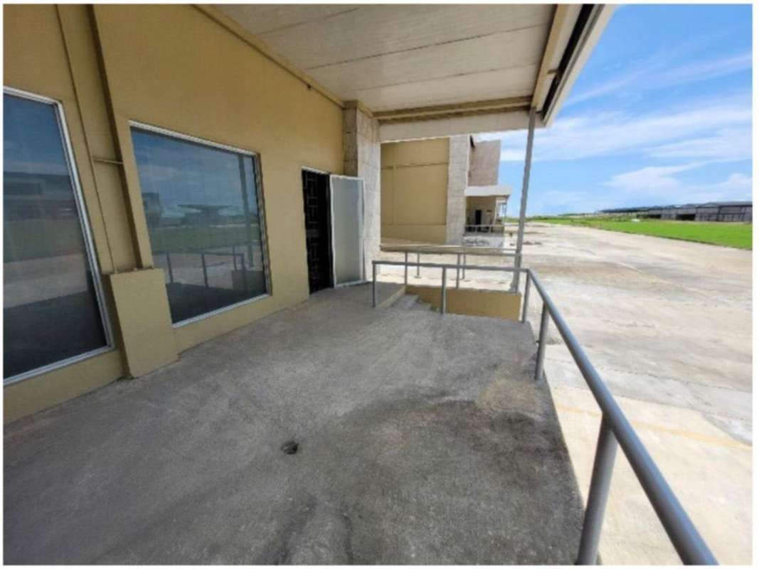 Commercial warehouse exterior with concrete loading platform, ramp access and metal canopy in Panama