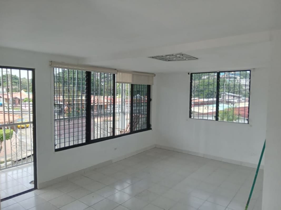 Bright living room with security barred windows, white tile floor and balcony access Panama
