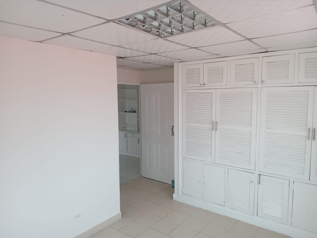 Bedroom with built-in closet and window with roller shade in Villa Lucre Panama