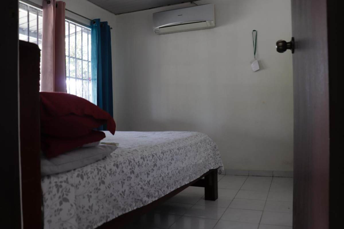 Simple bedroom with AC and floral bed covers in Punta del Este Tocumen Panama