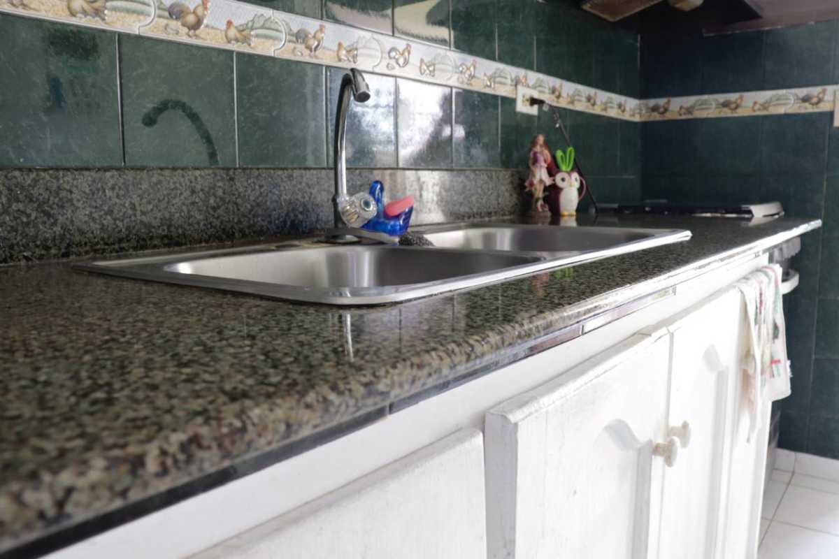 Traditional kitchen with granite countertop and double sink slate green tiles Punta del Este Panama