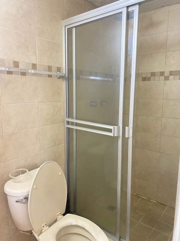 Bathroom with modern ceramic tiles and glass shower door PH Residencial Las Palmeras Panama City