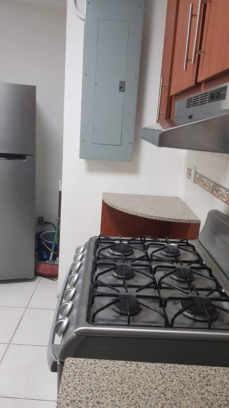 Compact kitchen with granite countertops refrigerator stove Betania office