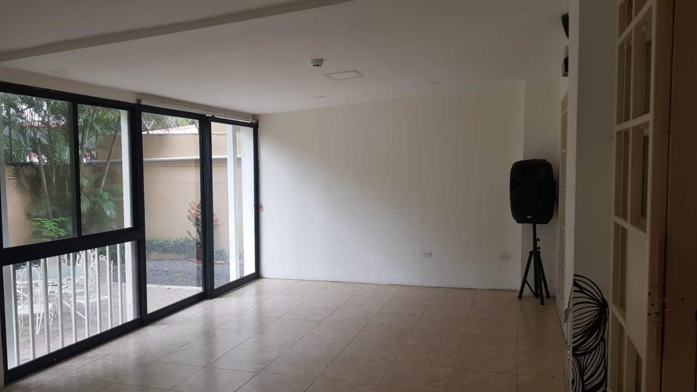 Minimalist lounge/waiting area with sliding glass doors opening to patio Betania Panama