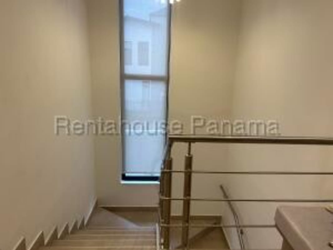 Bright staircase with metal railing and large window PH Costa Linda Costa Sur Panama