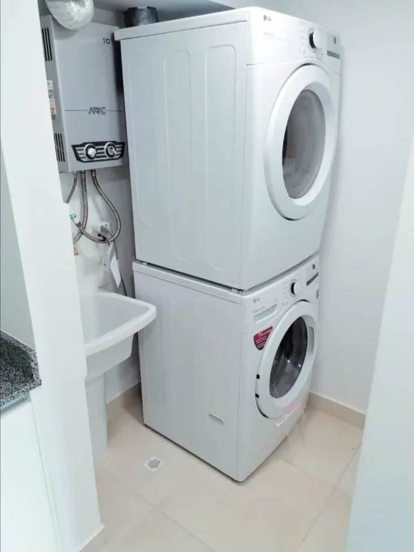 Laundry area with stacked washer dryer and water heater in rental apartment Panama City