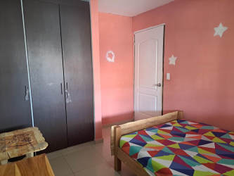 Bedroom with pink walls, colorful bedding, wardrobe in La Chorrera Panama