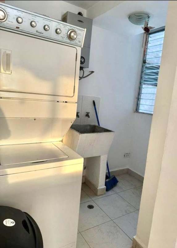 Laundry with stacked washer dryer, utility sink in PH Central Park Panama City