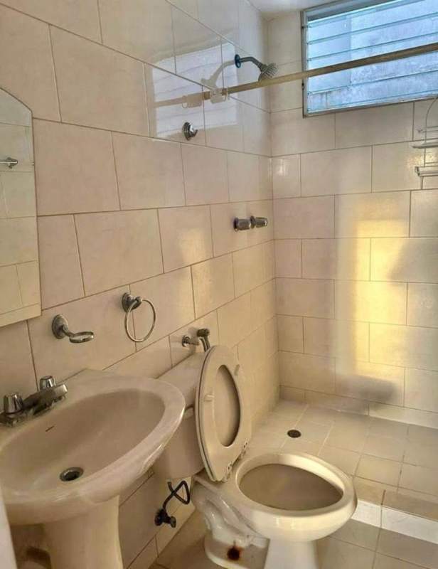 Minimalist bathroom with pedestal sink, shower area in PH Central Park Panama City