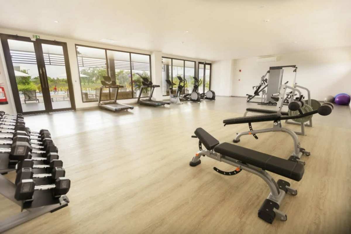 Bright gym with modern equipment, treadmills, mirrors, wood floors in Brisas del Golf Panama City