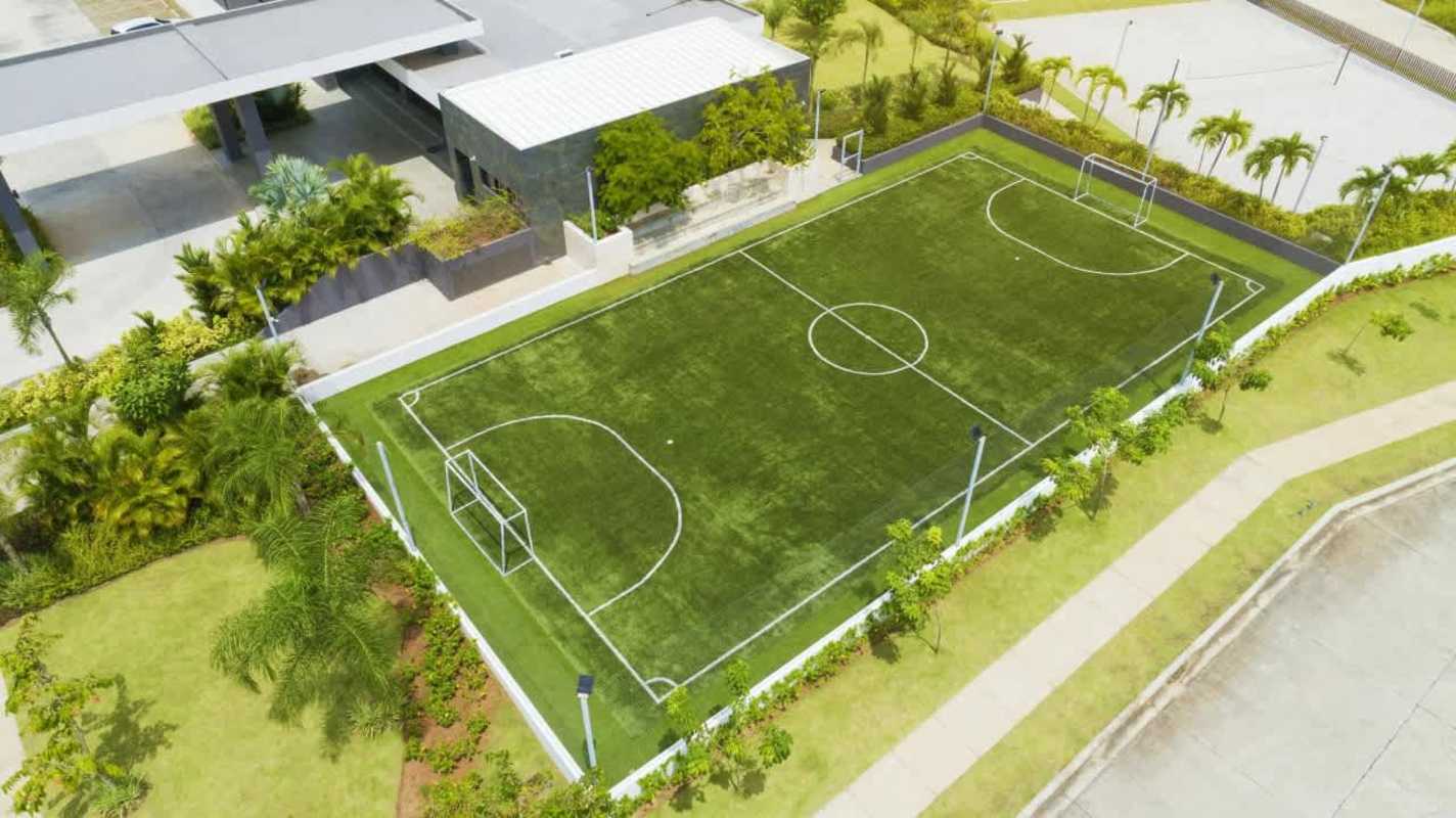 Aerial showing soccer field, tennis courts, palm trees, parking Brisas del Golf Panama City