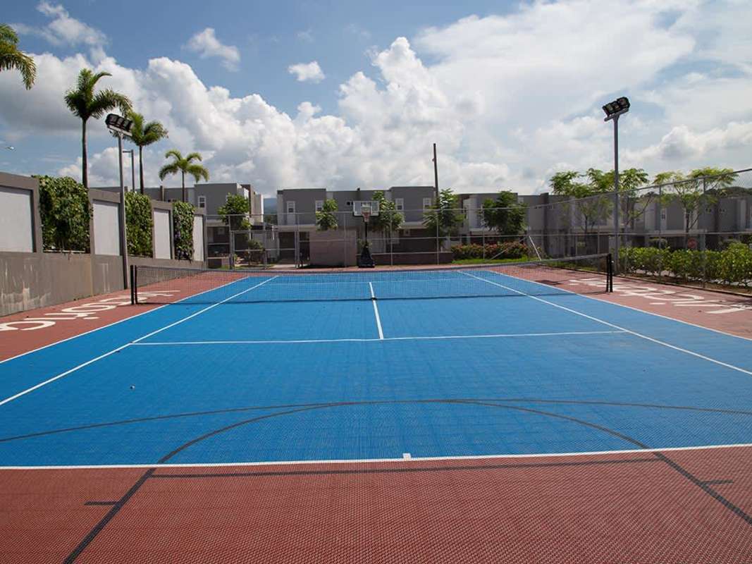 Colorful outdoor multi-sports court, basketball hoops, tennis net in Brisas del Golf community