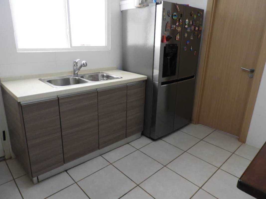 Kitchen with large fridge, double stainless sink, window and wood cabinets Brisas del Golf Panama