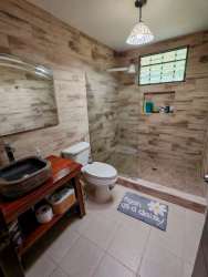 Rustic bathroom with wood-look tiles and walk-in shower in mountain house El Valle Panama