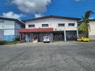 Two-story industrial warehouse building with large garage doors in Colón Panama