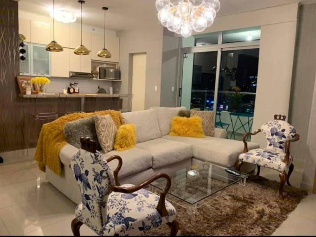 Open concept living space with balcony access, sectional sofa, floral chairs and dining area PH Roma Tower Panama