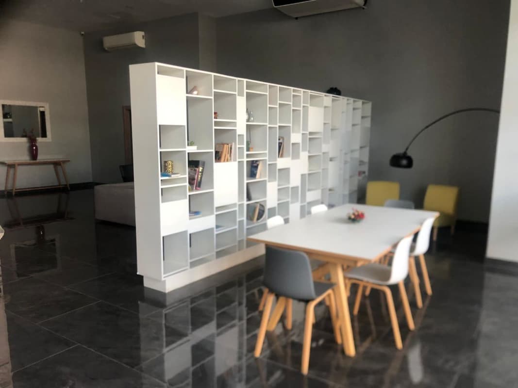 Minimalist modern living and dining area with bookcase partition at PH Roma Tower Panama
