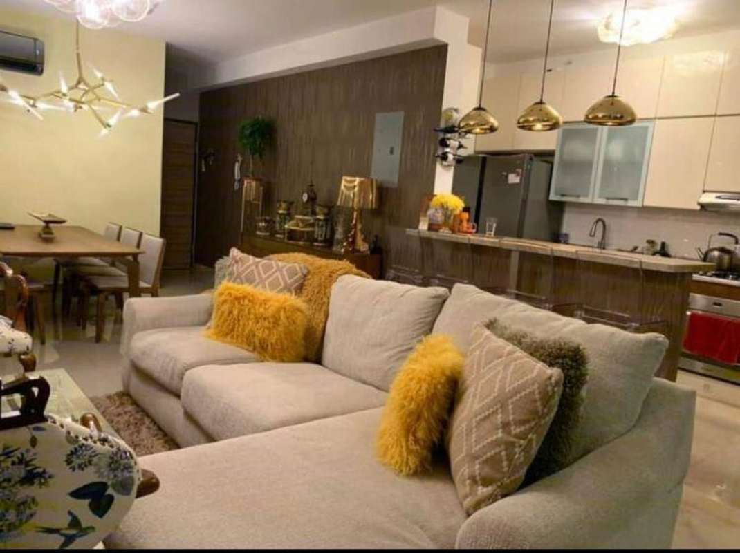 Modern open-plan living with sectional sofa, dining area, kitchen and pendant lights in PH Roma Tower Panama