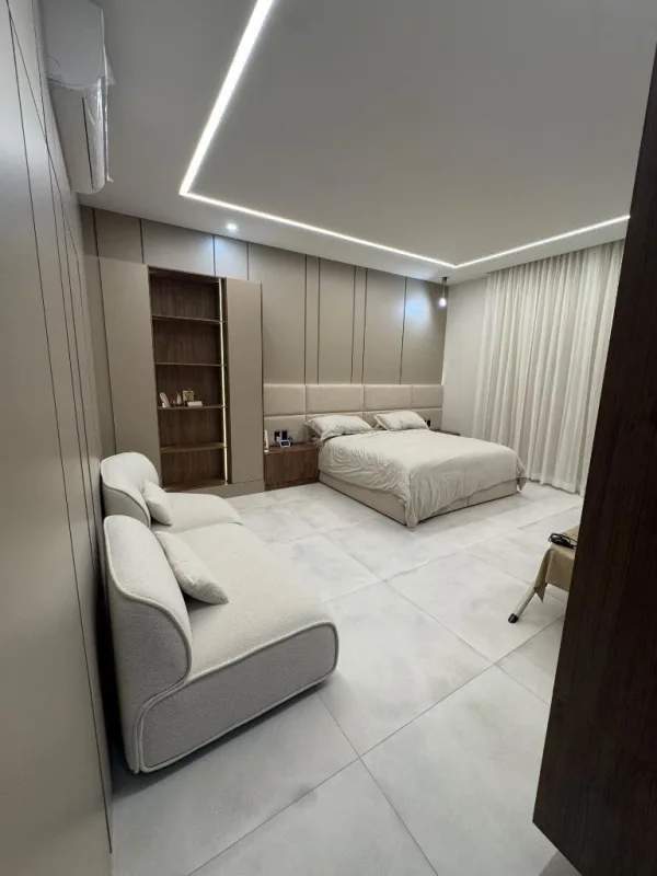 Modern bedroom with minimalist decor, integrated lighting, neutral colors at Santa Maria