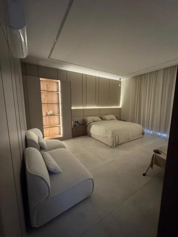 Modern large bedroom with ambient LED lighting, neutral tones, floor-to-ceiling curtains in Santa Maria