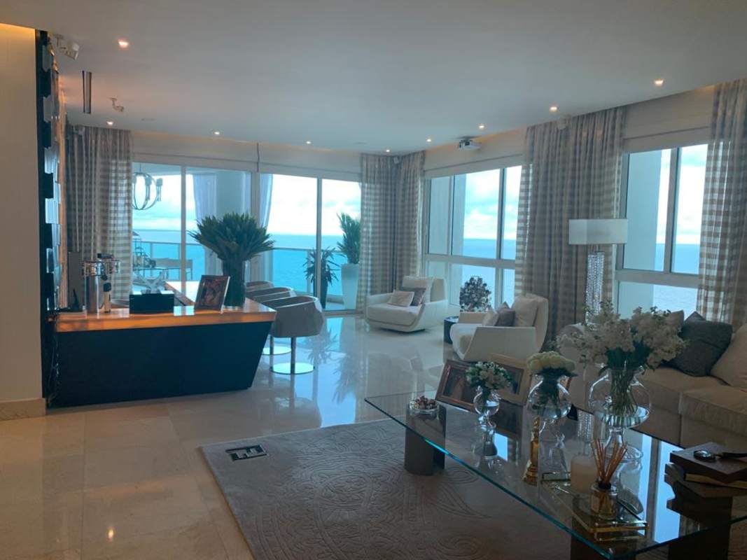 Elegant dining room with glass table, chandelier and marble flooring in luxury Venetian Tower apartment