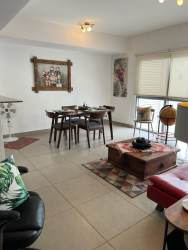 Living room with sofa, art and access to balcony for sale furnished in PH Mosaic Panama Pacifico
