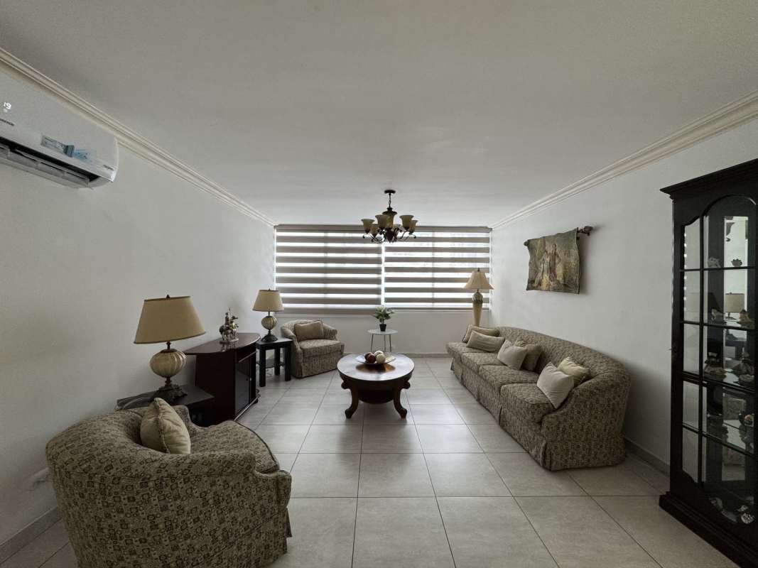 Large living room with sofas, blinds, chandelier lighting in Marbella apartment for rent Panama