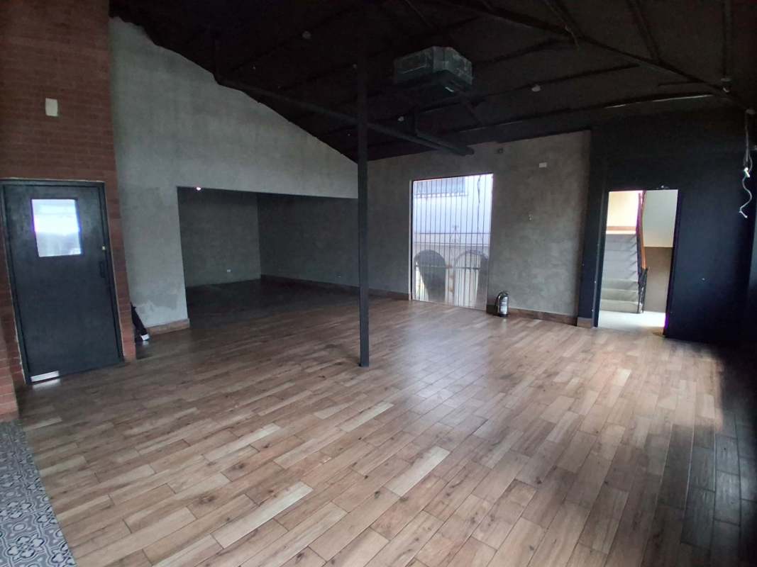 Empty office or commercial space with exposed brick, wood floors, and industrial ceiling in Coco del Mar Panama