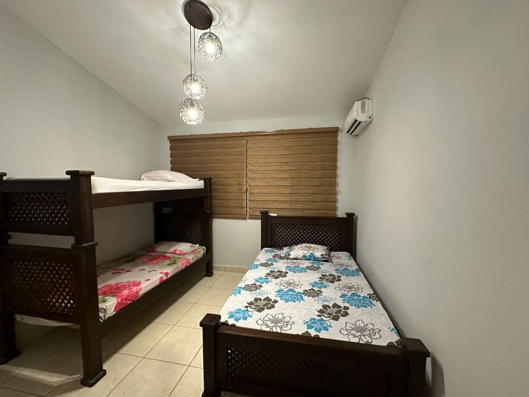 Contemporary living room with mirror decoration, tile floors, wood furniture at Playa Gorgona home