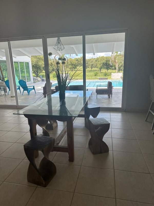 Dining area with glass table, window view to terrace and pool in Gorgona house rental