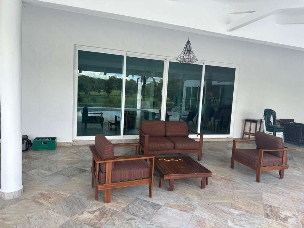 Outdoor covered patio with wood table chairs sliding glass doors at Playa Malibu Gorgona rental