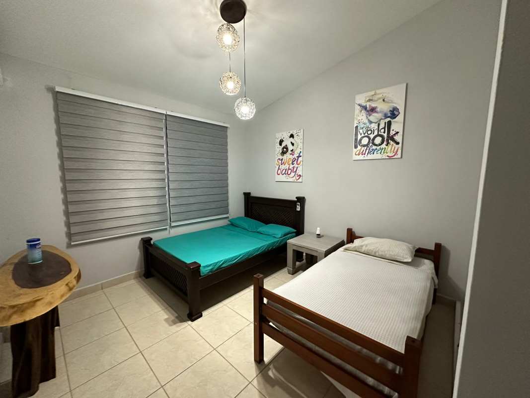 Bedroom with double and single bed, gray walls, pendant lights, tiled floor at Malibu Playa Gorgona