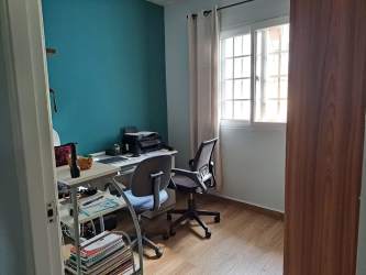 Functional home office room with teal accent wall natural light and wood flooring in La Chorrera house