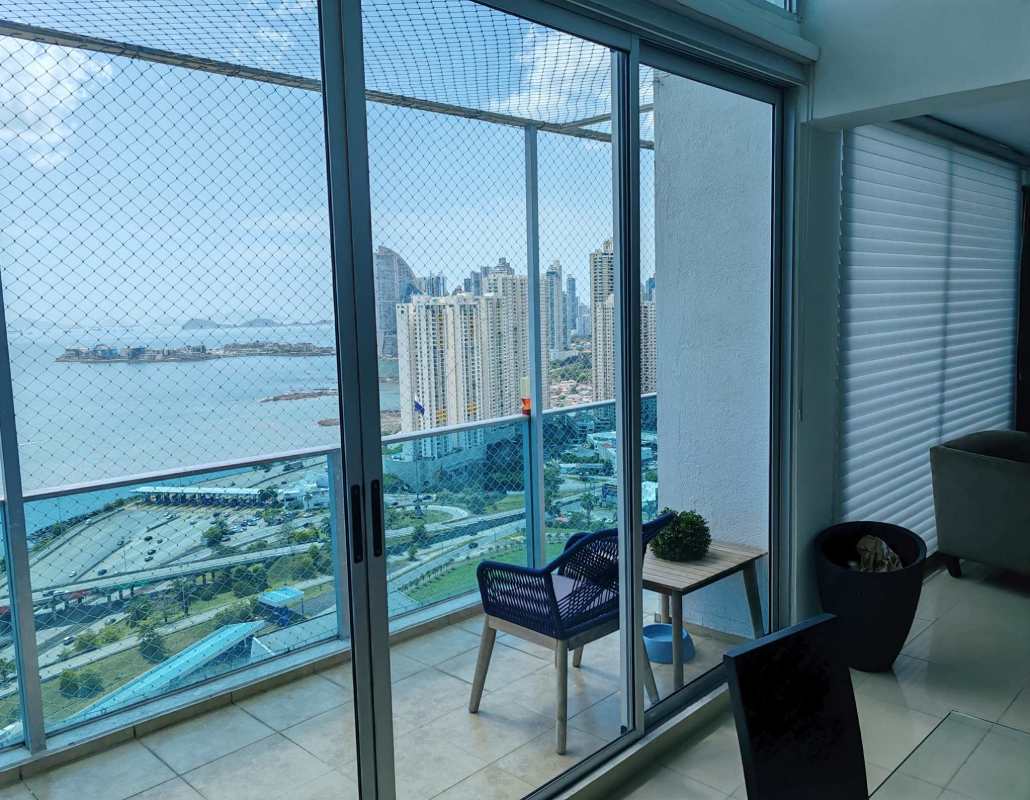 Elegant dining space opening to ocean view balcony in furnished loft PH Seawaves Panama City