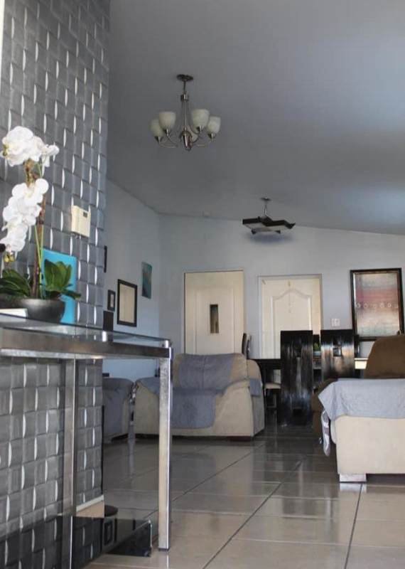 Contemporary living room with textured accent wall, sofas, dining area and tiled flooring in Panama City