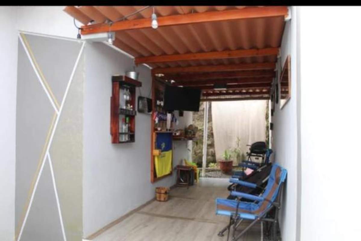 Entertainment terrace with BBQ grill, TV, bar area, string lights and tile roof at Brisas del Golf house