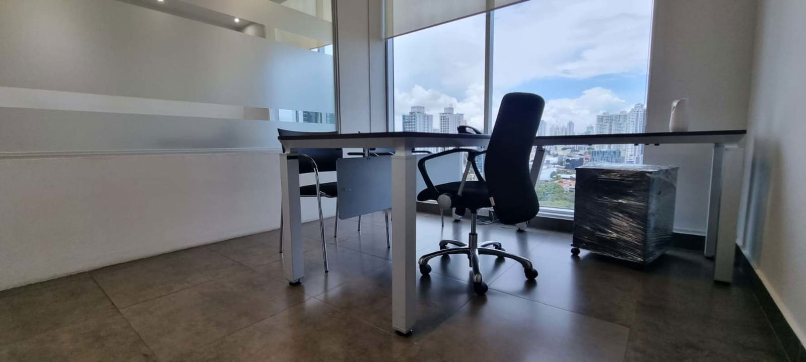 Minimalist reception with glass desk and gray accent wall at PH Obarrio Business Center Panama