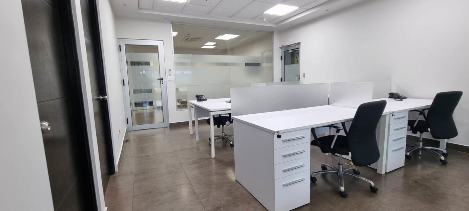 Modern minimalist work area with desks glass partitions PH Obarrio Business Center Panama