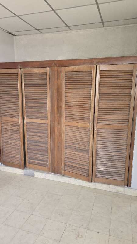 Bedroom with wooden closet doors and tile floor in Panama house for sale