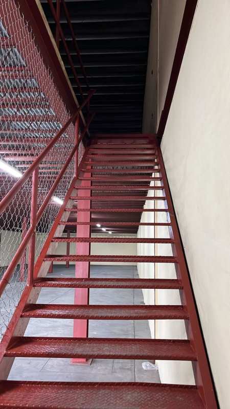 Red industrial staircase mezzanine inside commercial warehouse El Crisol Panama