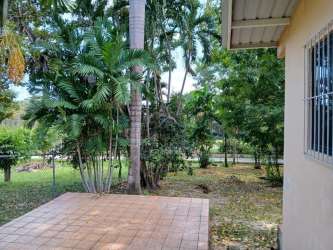 Open kitchen and dining with pass-through, white walls and tiled floor at Coronado beach house Panama