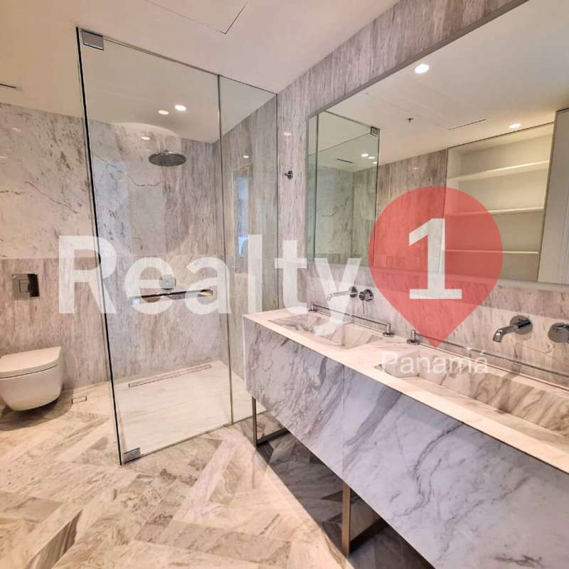 Luxury bathroom with marble walls, double vanity sink, glass shower in PH Wanders & Yoo Panama City