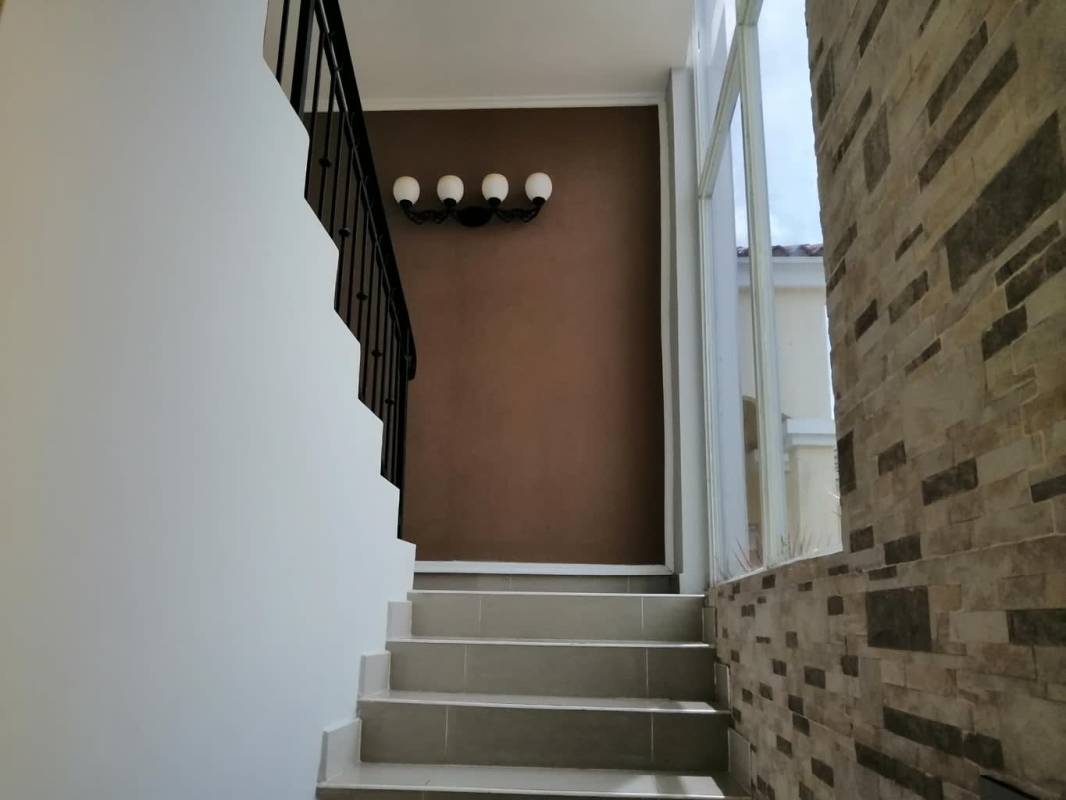 Indoor staircase with floor to ceiling window, black railing in Green Field Clayton house