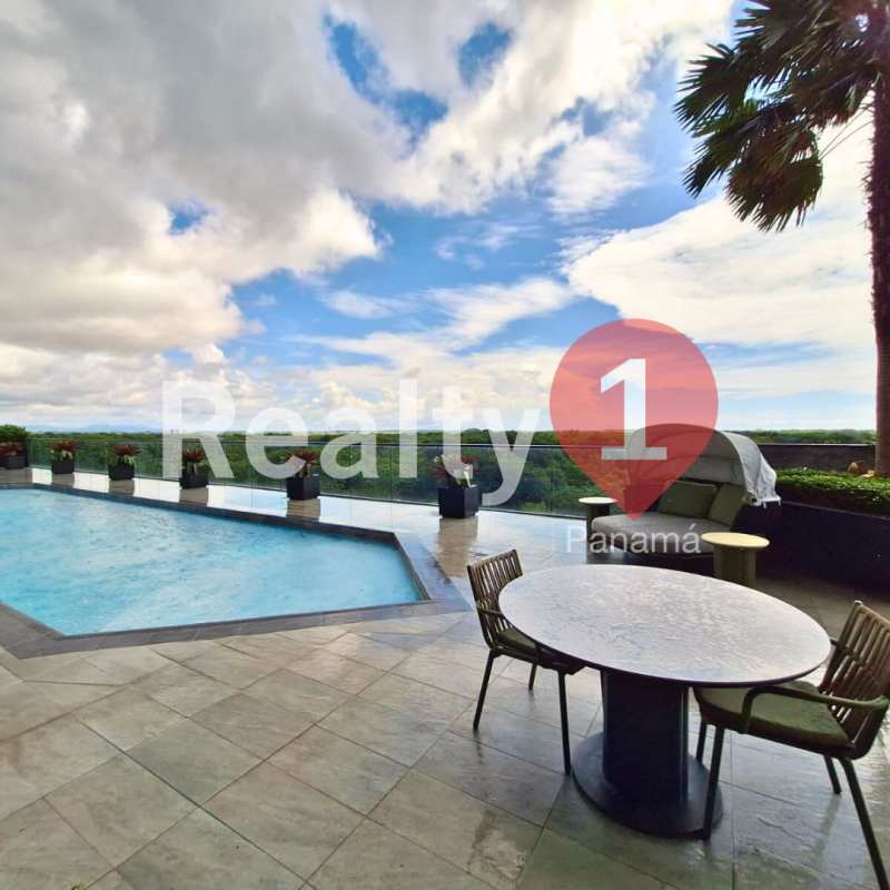 Infinity pool overlooking golf course with lounge area at Empire Residences Santa María Panama City