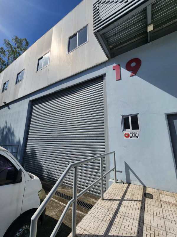 Front view of industrial warehouse with roll-up doors and parking Tocumen area Panama